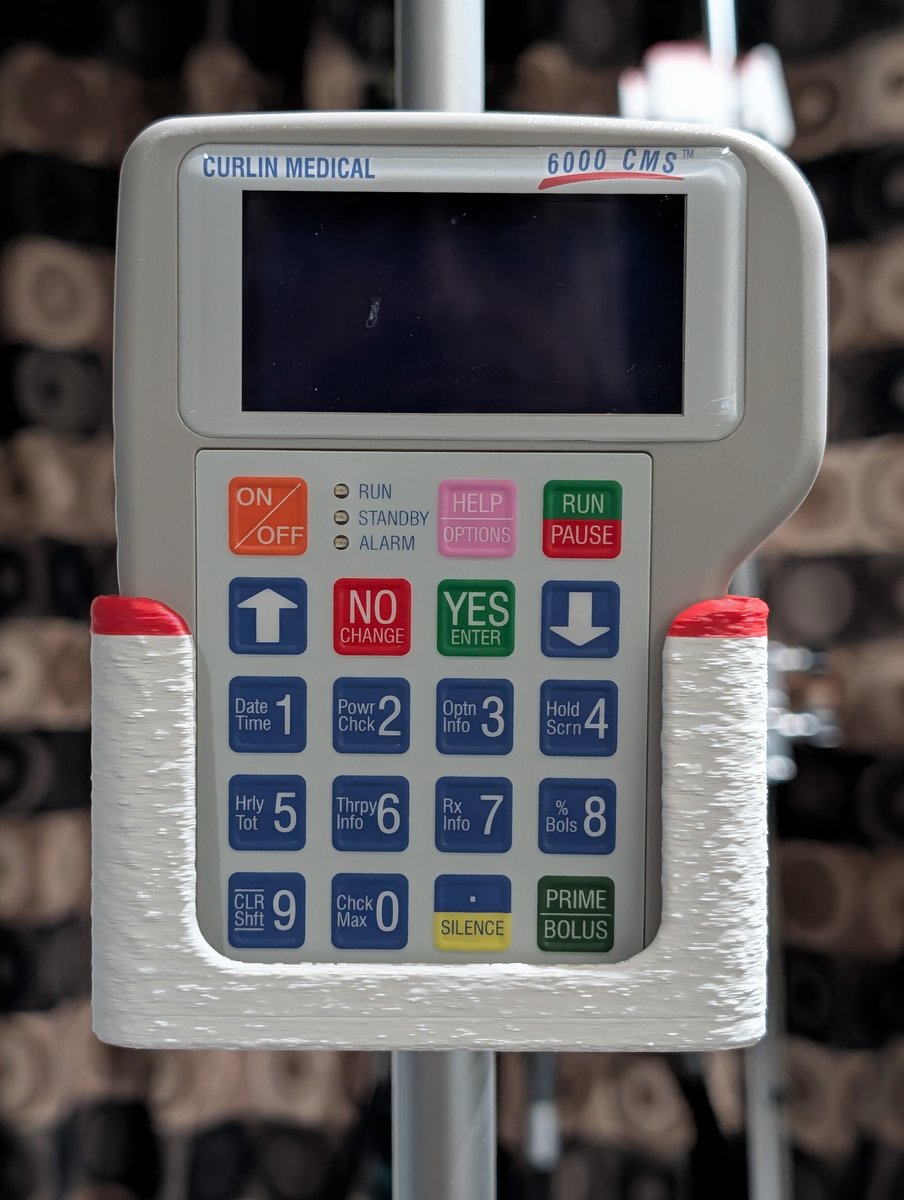 Compact device seated in the OpenPoleMount v3 cradle on a home IV pole